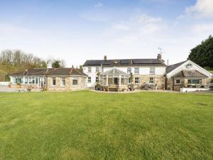 an exterior view of a large house with a large yard at Chapel Green Studio in St Austell