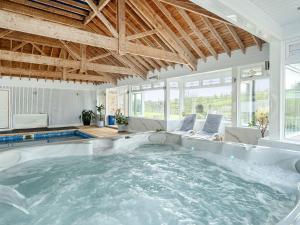 a large hot tub in a room with windows at Chapel Green Studio in St Austell