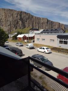 a parking lot with cars parked in front of a mountain at Cerro Chaltén House - Deptos in El Chalten