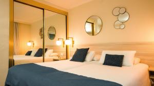 two beds in a hotel room with two mirrors at Nura Houses Condor in Playa de Palma +32 photos