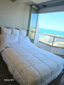 a large bed in a room with a large window at Sheraton Royal Sea View in Alexandria