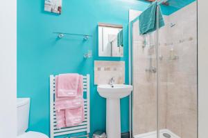 a blue bathroom with a sink and a shower at Roundabout Farm in Thurning +26 photos