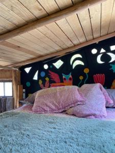 ein Schlafzimmer mit einem Bett und einer farbenfrohen Wand in der Unterkunft Barbablancaspa in San José de Maipo