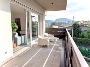 a balcony with white chairs and a table on it at Pantone - Sarnico Color Suites in Sarnico