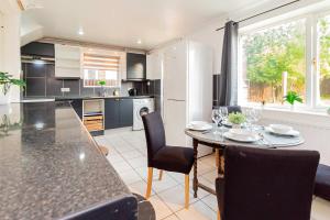 a kitchen and dining room with a table and chairs at Comfortable 3BED House with Garden & Parking in Colchester