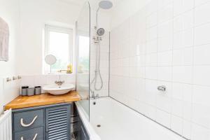 a bathroom with a tub and a sink and a shower at Comfortable 3BED House with Garden & Parking in Colchester