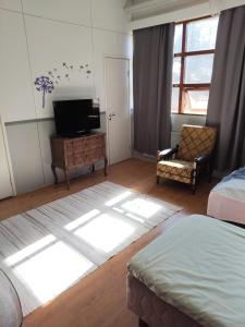 a bedroom with a bed and a tv and a window at Willa Witsari 27m2 in Kokkola