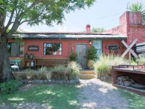 an old red house with a tree in the yard at casa montepio in San Antonio de Areco