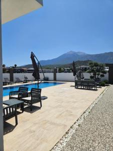 a patio with benches and a swimming pool at KALİDA APART in Kemer
