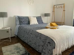a bedroom with a bed with a blue comforter at Casa Ti Carolina in Nazaré +47 photos