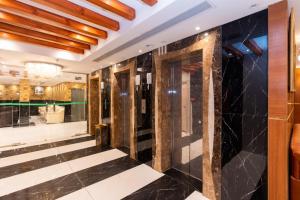 a lobby of a hotel with black tile and a door at فندق برج العالم 2 in Mecca