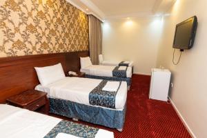 a hotel room with two beds and a flat screen tv at فندق برج العالم 2 in Mecca
