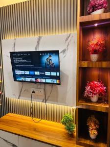 ein Flachbildfernseher, der an einer Wand hängt in der Unterkunft Cloud Meadows in Jāmb