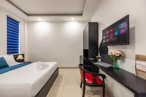 a bedroom with a bed and a desk with a computer at Hotel Trung Mai-Sân Bay in Ho Chi Minh City