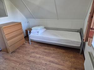 a small bedroom with a bed and a dresser at vacation home 68 in Tzummarum