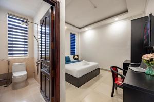 a bathroom with a bed and a toilet and a desk at Hotel Trung Mai-Sân Bay in Ho Chi Minh City +19 photos