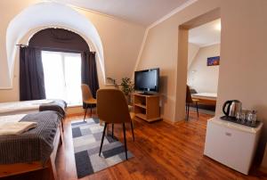 a room with a bed and a tv and a window at Mátyás Szállás Panzió in Szombathely