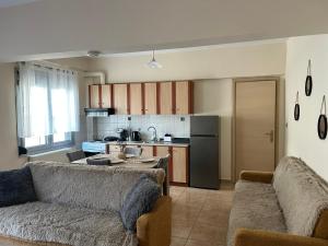 a living room with two couches and a kitchen at The Clock House No1 in Grevena