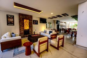 a living room with a couch and chairs and a fireplace at Hotel Boutique La Torre in Tupiza