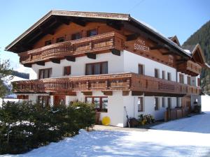 ein Gebäude mit Holzbalkonen darauf im Schnee in der Unterkunft Haus Sonneck in Niederthai