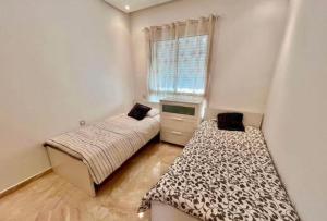 a bedroom with two beds and a television in it at saviohome in Ouarzazate