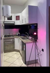 a kitchen with purple walls and a counter with a light at saviohome in Ouarzazate