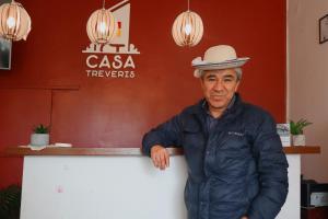 a man wearing a hat standing next to a counter at Casa Tréveris in Sucre