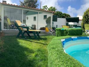 a backyard with a pool and a table and chairs at Casa Ti Carolina in Nazaré