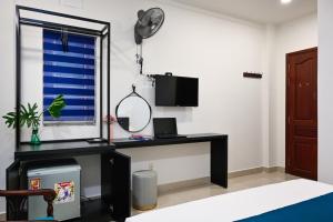 a room with a desk and a mirror and a window at Hotel Trung Mai-Sân Bay in Ho Chi Minh City