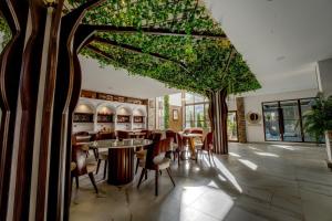 a restaurant with tables and chairs and a tree at Hotel Boutique La Torre in Tupiza
