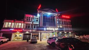 a building with cars parked in front of it at night at Hotel Ayodhya Inn in Lokāpur