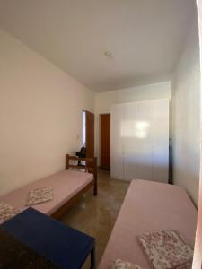 a room with two beds and a cabinet at Miscelânea Hostel in Sete Lagoas