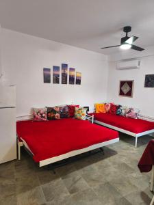 two beds in a room with red sheets at Blue Port Faros - Sifnos in Faros