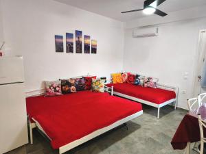 two beds in a room with red sheets at Blue Port Faros - Sifnos in Faros