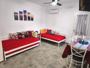 a living room with two beds and a table at Blue Port Faros - Sifnos in Faros