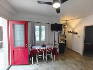 a room with a red door and a table with chairs at Blue Port Faros - Sifnos in Faros +33 photos