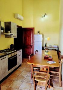 a kitchen with a wooden table and a refrigerator at B&B Sa Sinniesa in Sìnnai