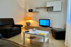 a living room with a couch and a tv at Mar e Sol by - T3 , wi-fi e estacionamento in Quarteira