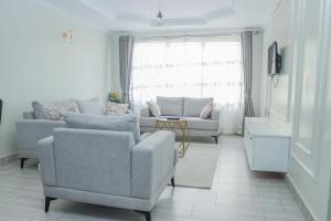 a living room with two chairs and a couch at D&H Homes Milimani Nakuru-Elegant 2 Bedroom Apartment in Nakuru