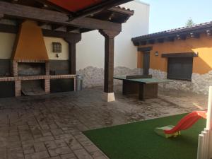 a house with a patio with a table and a fireplace at Casa Regidor2 in Rábano