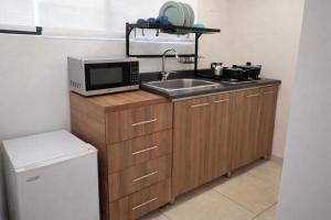 a small kitchen with a sink and a microwave at Apartaestudio con parqueadero cerca UPTC y Clínica Los Andes in Tunja +2 photos