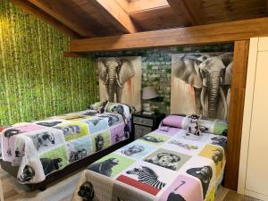 two beds in a room with a mural of an elephant at Casa Regidor2 in Rábano +56 photos
