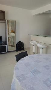 a room with a bed and a table and a piano at Apartamento Completo Duas Quadras do Mar in Capão da Canoa +15 photos