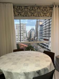 a large window with a view of a city at Apartamento Completo Duas Quadras do Mar in Capão da Canoa