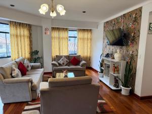 a living room with two couches and a tv at Hotel-Apartment INKASABIOS in Cusco