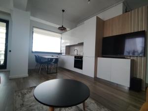 a living room with a table and a tv at Premium Lakeside Apartament Building Stefan in Mamaia