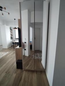 a mirror in a living room with a wooden floor at Premium Lakeside Apartament Building Stefan in Mamaia