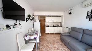 a living room with a couch and a table at Estudio con piscina in Roses