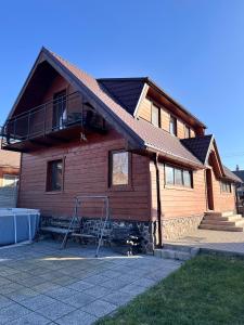 a wooden house with a porch and a balcony at Chalupa u Jožka in Betlanovce