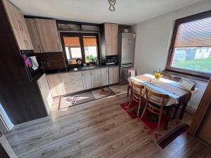 a kitchen with a dining room table and a refrigerator at Chalupa u Jožka in Betlanovce